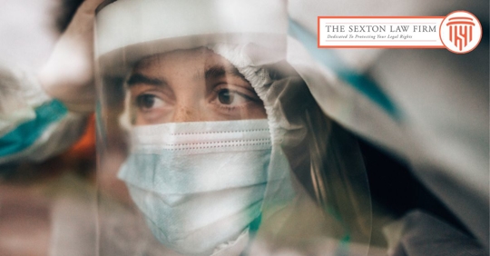 Healthcare worker looking out a window of a hospital